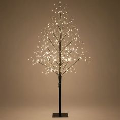 a lighted christmas tree with white lights in the shape of a tree on a black stand