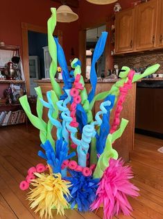 a vase filled with lots of colorful streamers on top of a hard wood floor