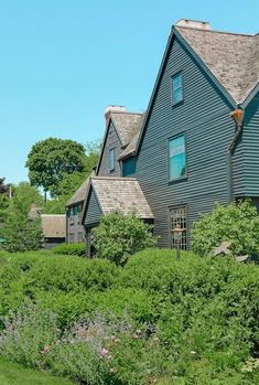 an old house is surrounded by lush green bushes