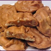 a pile of peanut butter cookies sitting on top of a white plate covered in caramel