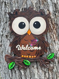 an owl is sitting on a tree with the word welcome painted on it's face