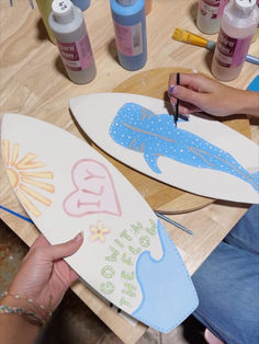 two surfboards are being painted with pastel and watercolors on the table