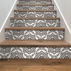 the stairs are painted with black and white designs on them, along with wood flooring