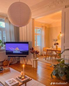 a living room filled with furniture and a flat screen tv on top of a wooden table