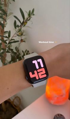 an apple watch on someone's wrist with the time displayed in red and pink