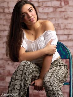 a woman sitting on a chair with her arms crossed