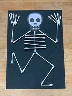 a skeleton made out of sticks on top of a wooden floor with an arrow in the middle