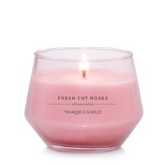 a pink candle sitting in front of a white background