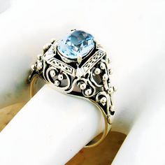 Vintage Estate Simulated Aquamarine Solitaire Filigree Ring. Intricate Heart Shaped Details. 925 Solid Sterling Silver. The Top Of The Ring Measures 1/2 Inch In Length. Set With One High Quality 8x6 mm Simulated Aquamarine Stone. Stamped 925.  Excellent Condition/Like New. Classic Silver Blue Topaz Birthstone Ring, Classic Sterling Silver Topaz Birthstone Ring, Silver Hallmarked Rings With Blue Topaz, Vintage Hallmarked Topaz Ring In Sterling Silver, Silver Blue Topaz Hallmarked Rings, Hallmarked Oval Topaz Ring In Sterling Silver, Sterling Silver Hallmarked Topaz Ring For Anniversary, Silver Blue Topaz Rings Hallmarked, Sterling Silver Topaz Anniversary Ring