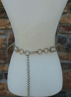 This is a vintage silver metal rhinestone chain belt with rectangular and circle shaped links. The rectangle links are decorated with clear sparkly rhinestones. It has an adjustable chain and a hook closure. It's in excellent condition. Measurements: Total length 48.5 inches Adjusting chain length 21 inches Adjustable from 28 to 46 inches Width 1 inch at widest point Virtually everything we sell has been previously worn/used so it is likely to show some degree of evidence of that. There will be Party Jewelry With Metal Decoration, Vintage Silver Adjustable Chain Belt, Silver Metal Chain Belt With Metal Decoration, Adjustable Silver Metal Chain Belt, Silver Metal Waist Chain With Chain Strap, Adjustable Metal Chain Belt For Formal Occasions, Elegant Silver Metal Chain Belt, Silver Chain Link Waist Chain For Party, Vintage Silver Chain Belt For Party