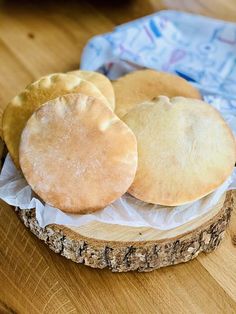 three cookies sitting on top of a piece of wood next to a baguette