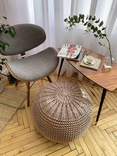 two chairs and a table in a room with wood flooring, one chair has a footstool on it