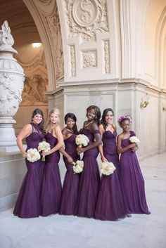 a group of bridesmaids in purple dresses posing for a photo at the palace