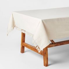 a wooden bench with a white table cloth on it's back end and legs