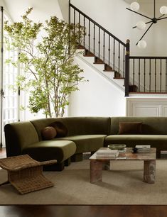 a living room filled with furniture and a stair case in front of the couches