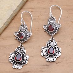 Traditional Balinese silver motifs evoke ornate garden gates in these elegant dangle earrings. Dewi Putera designs the earrings which are crafted of sterling silver and three carats of sparkling crimson garnet. Ornate Sterling Silver Earrings With Elegant Design, Ornate Sterling Silver Chandelier Earrings, Formal Sterling Silver Chandelier Earrings With Intricate Design, Ornate Sterling Silver Chandelier Earrings For Formal Occasions, Ornate Sterling Silver Chandelier Earrings For Formal Events, Ornate Dangle Jewelry, Sterling Silver Chandelier Earrings With Intricate Design, Sterling Silver Chandelier Earrings With Intricate Design For Gift, Elegant Teardrop Chandelier Earrings In Sterling Silver