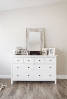 a white dresser and mirror in a room