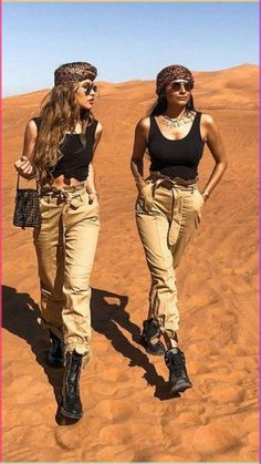 two women walking in the desert with their hands on their hipss and one has her hand on her hip