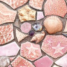 shells and seashells are arranged on a mosaic tile floor in the shape of a heart