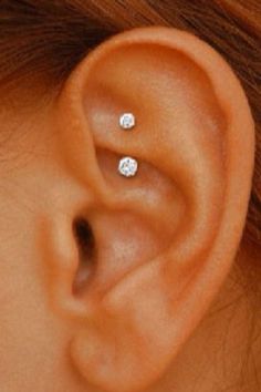 a woman's ear is shown with three small diamond studs on the side