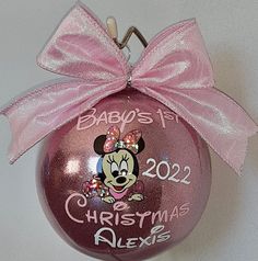 a baby's first christmas ornament with a minnie mouse face on it