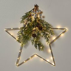 The Lit LED Hanging Star with Greenery in Silver from Wondershop™ is a simple yet stunning decorative piece for the holidays and beyond. This metal star sculpture light is adorned with 40 white LED bulbs that stay lit in a constant glow. It also includes faux pine greenery, pinecones and silver berries for added festive flair. The 14-inch size is perfect for wall and window display and the star is battery operated, so you can easily hang it anywhere you please with the attached metal ring. Wonde Star Sculpture, Snowflake Christmas Lights, Christmas Village Sets, Hanging Stars, Artificial Christmas Wreaths, Metal Star, Wood Christmas Tree, Christmas Greenery, Silver Bells