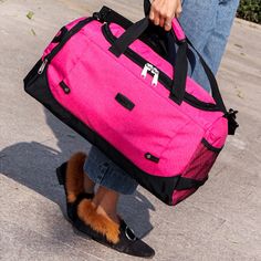 a woman carrying a pink duffel bag on her feet