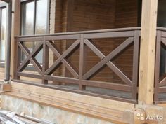 a wooden balcony with railings and windows