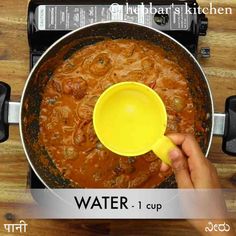 a person is stirring some food in a pot with a yellow spoon on the stove