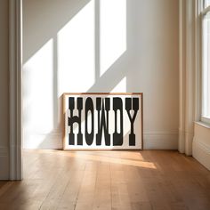 a wooden sign that says honey on the floor in front of a window with sunlight streaming through it