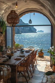 an outdoor dining area overlooking the ocean with chairs and table set for six, looking out to sea