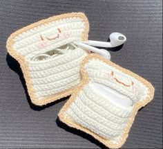 two crocheted toasters sitting on top of a table next to toothbrushes