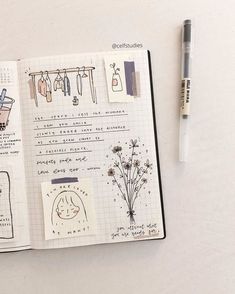 an open notebook with drawings on it and a pen sitting next to the pages that have been drawn