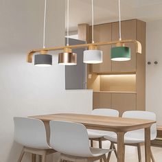 a wooden table with white chairs and lights hanging from it