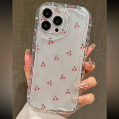 a clear case with cherries on it is held by a woman's hand