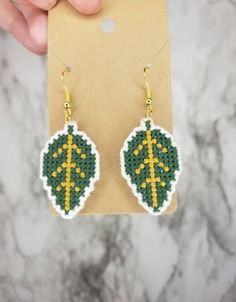 a pair of green and yellow beaded leaf earrings