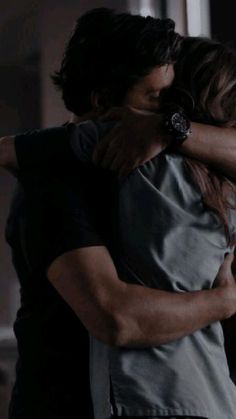 two people hugging each other in the dark