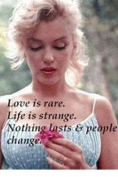 a woman holding a flower and looking down at her hand with the words love is rare life is strange nothing last & people change