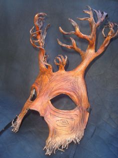 a wooden mask that has been made to look like an animal's head and branches