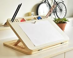 a desk with a white board and pen on top of it next to a clock