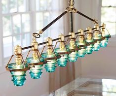 a chandelier hanging from the ceiling in a dining room with blue glass shades