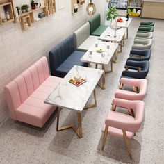 a row of tables and benches in a room with white tiles on the walls, along with pink chairs