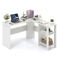 a computer desk with a laptop on top of it next to some books and plants