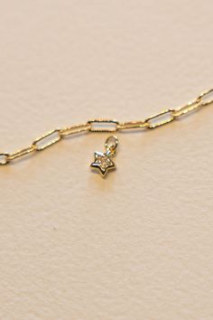 14k Gold filled small Shining Star charm is made to go on our charm necklaces or bracelets. This is a happy, sweet charm with a inner gem and star bezel setting that will pop on your necklace and mixes easily with our enamel or flat charms on one of our custom charm pieces. Hand make your custom charm necklace in Laguna Beach or build your piece online through adding a base necklace and your selection of charms. Leave us a note on your order for any special requests. 14K gold filled Tarnish resi Dainty 14k Gold Filled Star Charm Necklaces, 14k Gold Dainty Jewelry With Star Charm, Dainty 14k Gold Star Charm Jewelry, Dainty 14k Gold Filled Star Charm Necklace, Everyday 14k Gold Jewelry With Star Charm, Dainty Yellow Gold Star Charm Necklace, Yellow Gold Star Of David Charms Jewelry, Celestial Yellow Gold Charm Necklaces With Star Charm, 14k Gold-filled Yellow Gold Star Charm Jewelry