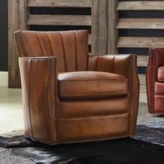 two brown leather chairs sitting next to each other on a black rug in front of a wooden wall