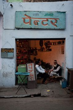 two men are sitting in the doorway of a building with an open door on it