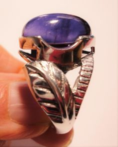 "Amethyst ring with a large pear shaped purple amethyst cabochon gemstone, set in a sterling silver leaf design ring, in a size 6 This vintage ring features a large royal purple amethyst pear amethyst cabochon, set in a solid sterling ring, with a beautiful large leaf embellishment on each side. The ring is a size 6. The polished bezel setting shows off the large, clear and very high quality genuine 16mm x 12mm amethyst jewel. It is stamped \"925\" for solid sterling inside the band. The ring ha Purple Amethyst Oval Cabochon Ring, Purple Amethyst Teardrop Ring, Purple Teardrop Gemstone Rings, Hallmarked Oval Cabochon Amethyst Ring, Teardrop Amethyst Ring In Purple, Purple Oval Cabochon Ring For Gift, Gift Amethyst Oval Cabochon Ring, Handmade Purple Amethyst Ring For Formal Occasions, Purple Cabochon Amethyst Ring