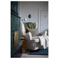 a living room with a chair, lamp and rug