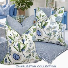 two blue and white pillows sitting on top of a couch