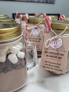 hot chocolate mix in mason jars with marshmallows and twine candy sticks